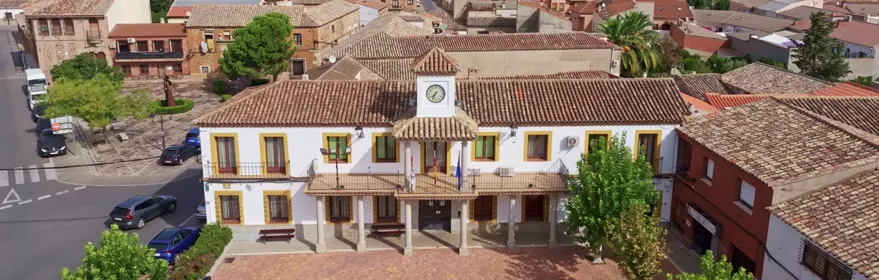 Vista aérea de edificio municipal con plaza adoquinada y calles del casco urbano