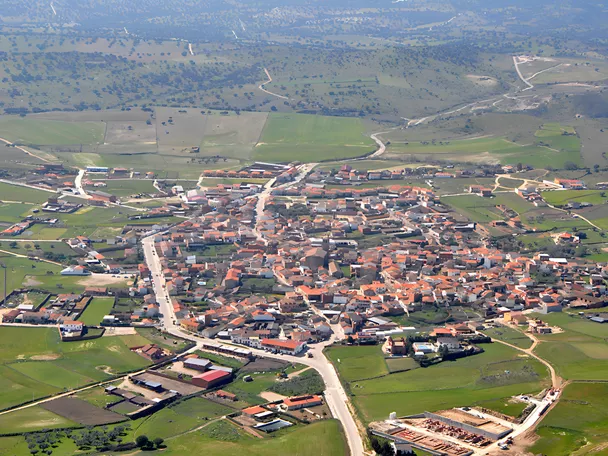 Vista aérea de pueblo rodeado de campos verdes y caminos