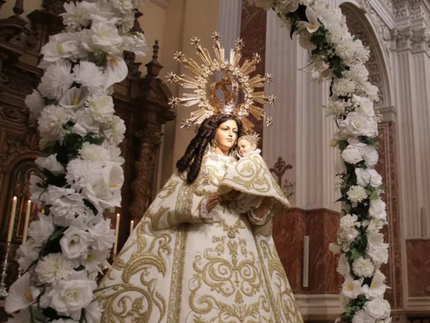 Imagen mariana con niño en altar barroco.