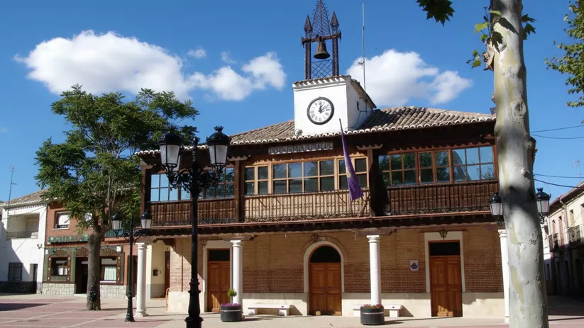 Fachada del ayuntamiento con reloj, soportales y plaza peatonal