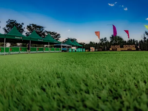 Espacio verde preparado para festival al aire libre con carpas y banderolas