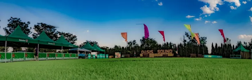 Espacio verde preparado para festival al aire libre con carpas y banderolas