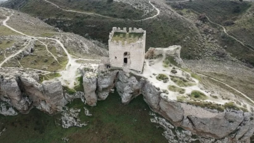 Vista aérea de torre fortificada sobre un farallón rocoso
