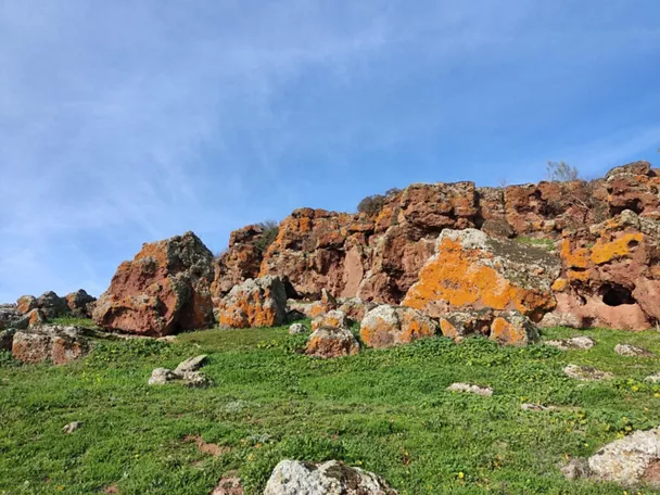 Afloramientos rocosos con líquenes sobre pradera verde