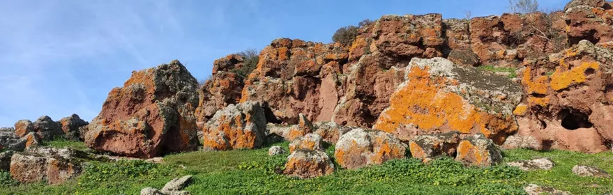 Afloramientos rocosos con líquenes sobre pradera verde
