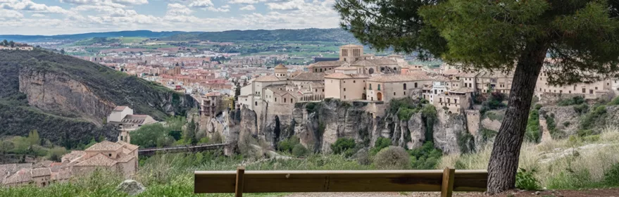 Vista panorámica del casco urbano rodeado de colinas y cielo despejado