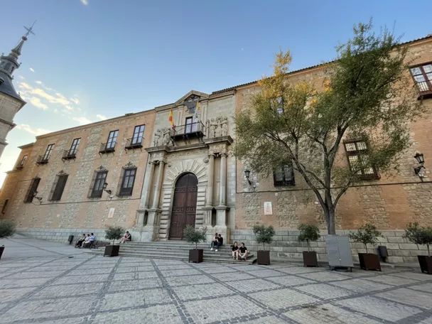 Fachada histórica de ladrillo y piedra con portada monumental y balcones.