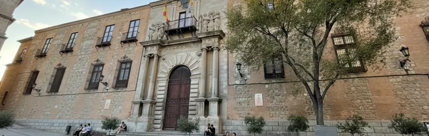 Fachada histórica de ladrillo y piedra con portada monumental y balcones.