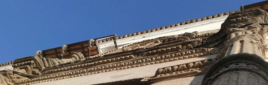 Detalle de portada de piedra decorada visto desde abajo