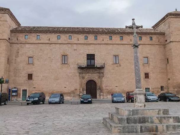 Palacio histórico en plaza mayor con columna de piedra