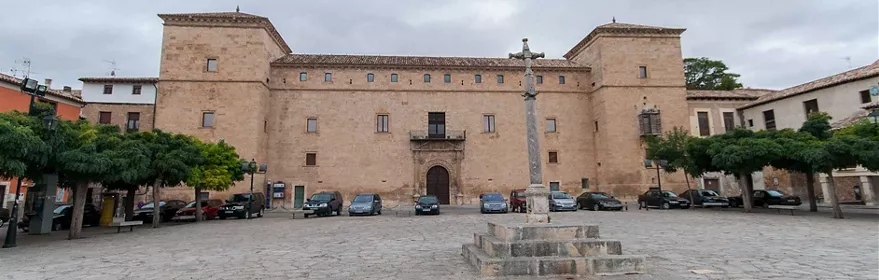 Palacio histórico en plaza mayor con columna de piedra