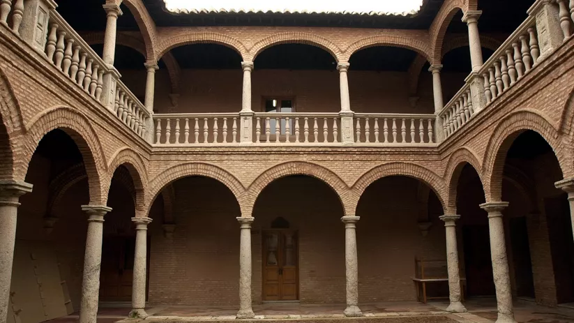 Patio interior con arcos de ladrillo y dos plantas