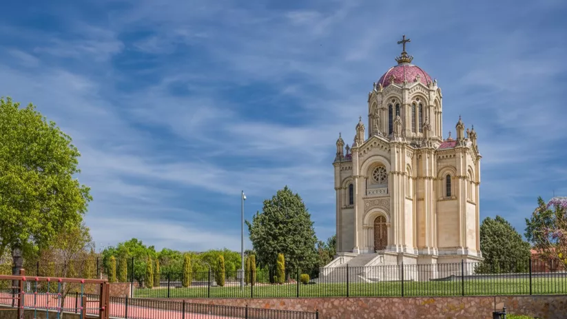 Mausoleo neogótico con cúpula roja en parque.