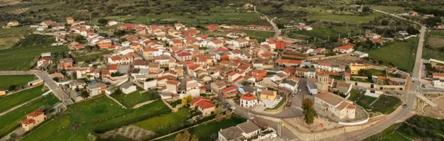 Vista aérea de un pueblo entre montes con rayos de sol
