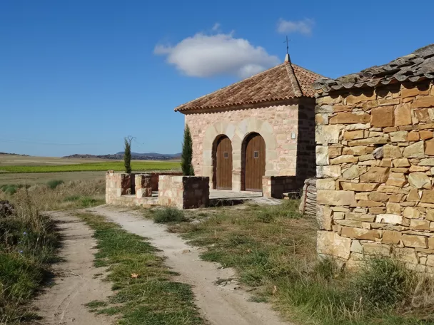 Núcleo rural entre colinas y prados al atardecer.