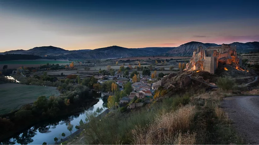 Castillo medieval sobre colina junto al río.