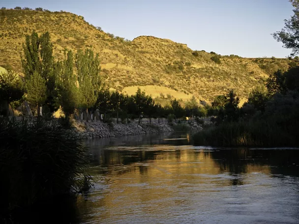 Río tranquilo entre montes y vegetación.