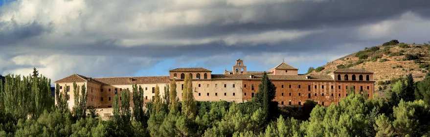 Gran monasterio histórico entre colinas.