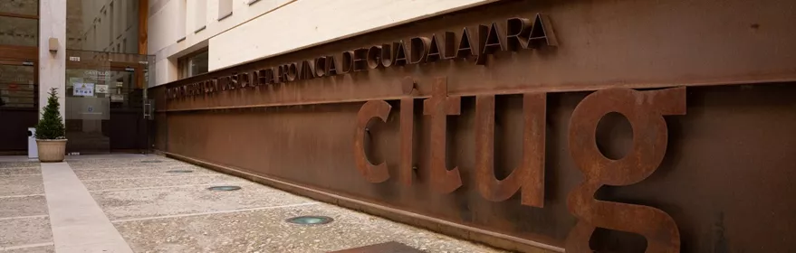 Fachada moderna junto a muro de piedra.