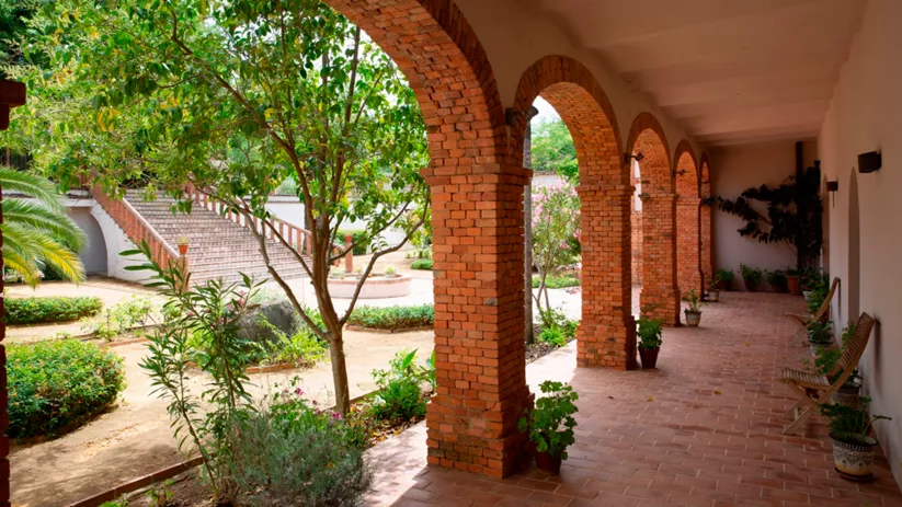Galería porticada con jardín interior y arcos de ladrillo