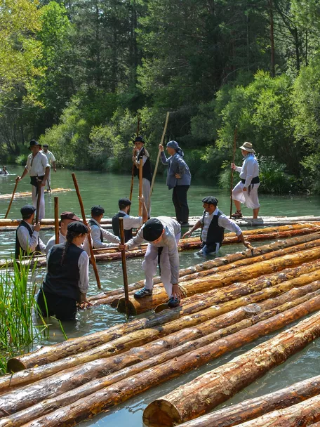 Transporte tradicional de troncos por el río.