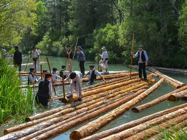 Transporte tradicional de troncos por el río.