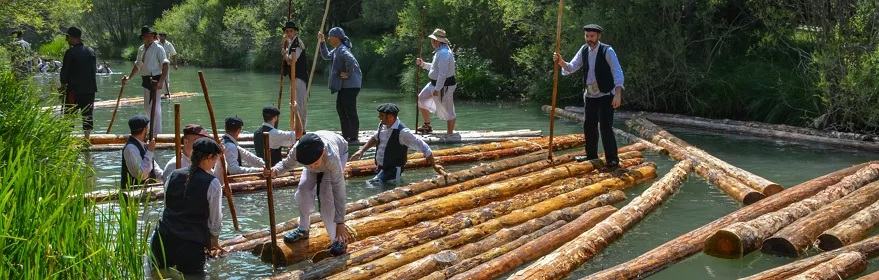 Transporte tradicional de troncos por el río.