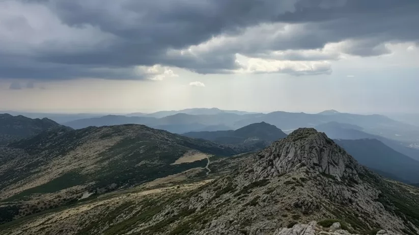 Crestas rocosas con nubes densas sobre el horizonte.