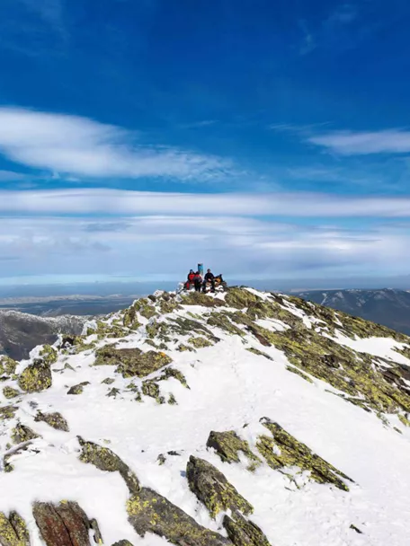 Montañeros en la cumbre de una montaña nevada.