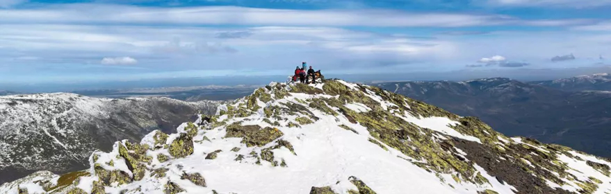 Montañeros en la cumbre de una montaña nevada.