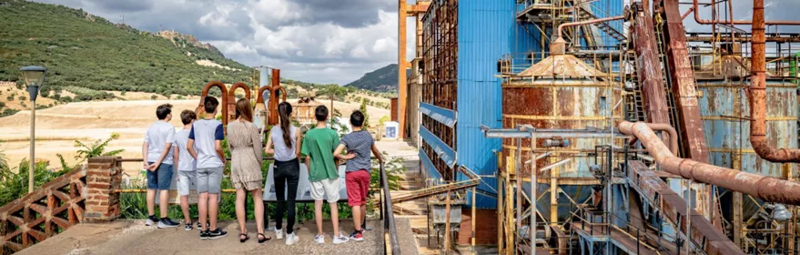 Grupo de visitantes observando antiguas instalaciones industriales