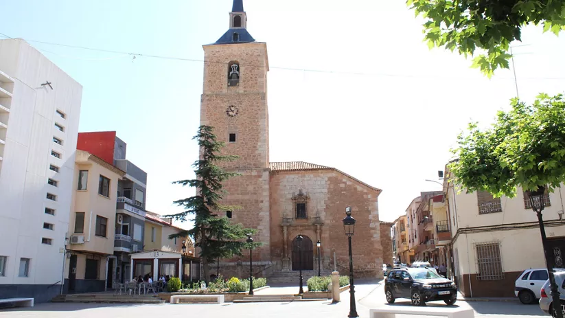 Torre de iglesia de piedra en una plaza urbana