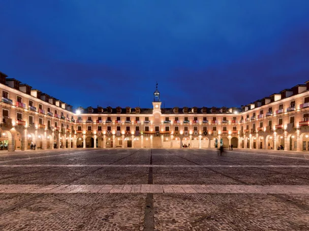 Plaza porticada iluminada de noche