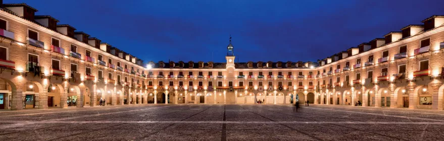 Plaza porticada iluminada de noche