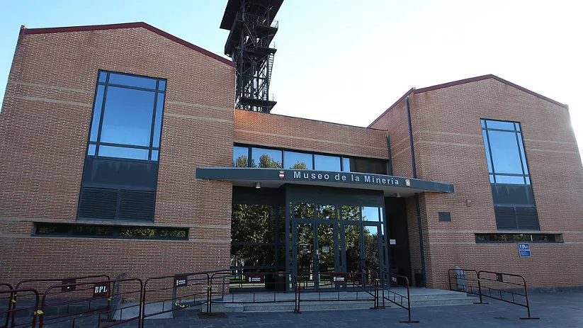 Fachada de museo industrial dedicado a la minería con entrada accesible y torre metálica al fondo