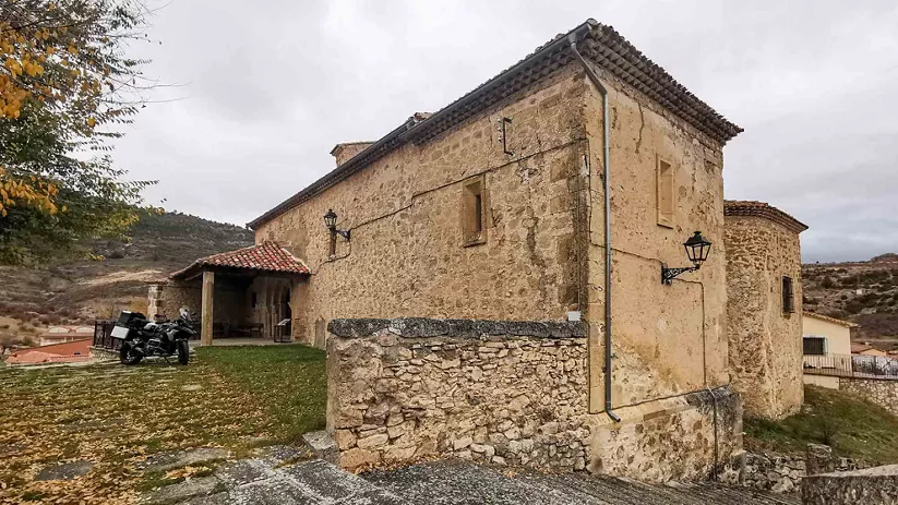 Edificio de piedra tradicional con tejado de teja y entorno rural.