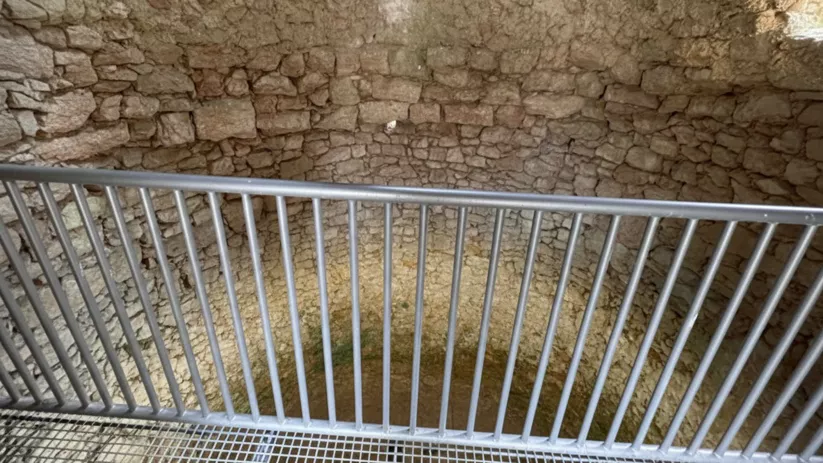 Interior de pozo circular con muros de piedra.