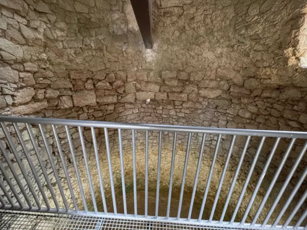 Interior de pozo circular con muros de piedra.