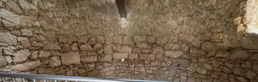 Interior de pozo circular con muros de piedra.