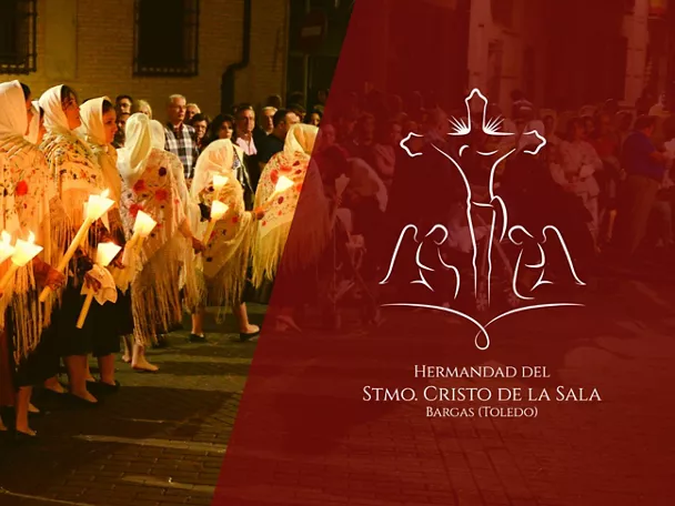 Personas con mantillas alineadas sosteniendo velas durante una procesión nocturna.