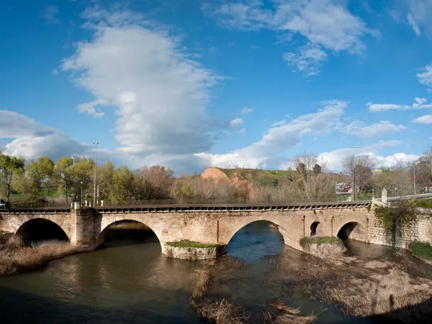 Puente histórico de piedra sobre río.