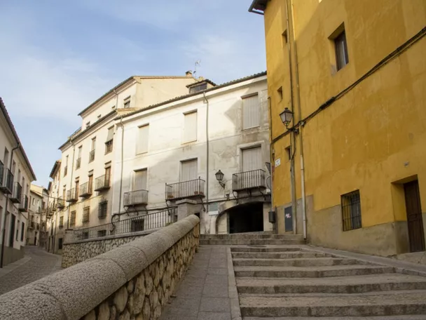 Escalinata junto a fachada histórica en calle estrecha