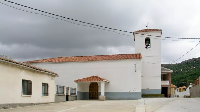 Iglesia blanca con espadaña y pequeña plaza