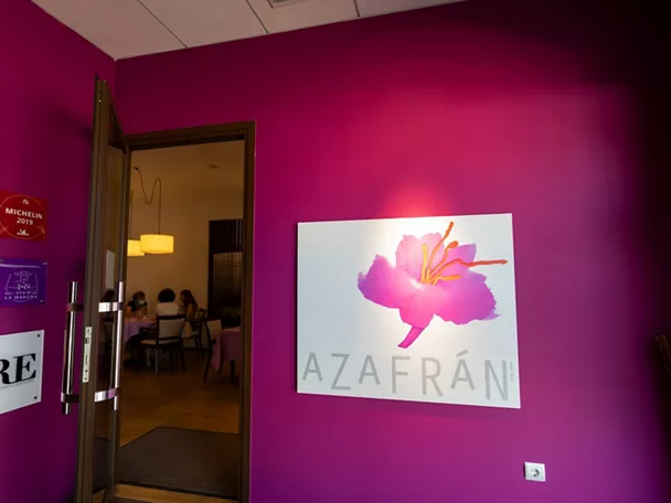 Entrada con pared fucsia y cartel floral