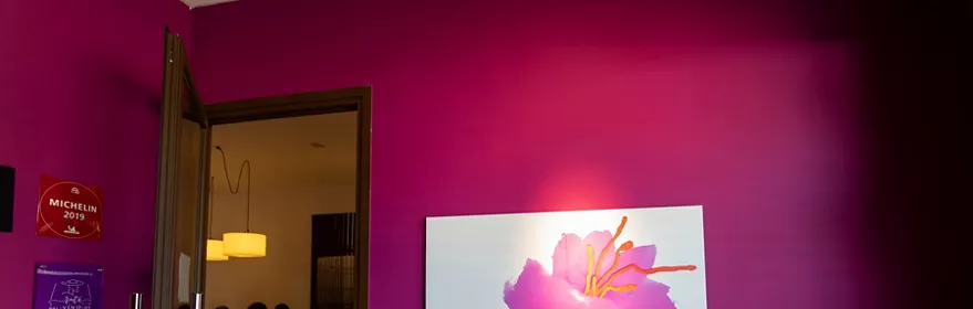 Entrada con pared fucsia y cartel floral