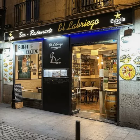 Fachada de bar restaurante en calle peatonal al atardecer.
