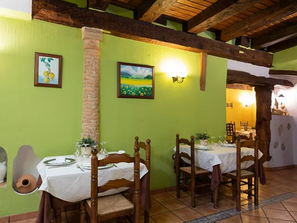 Comedor rústico con mesas vestidas y vigas de madera