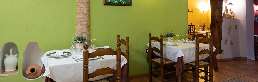 Comedor rústico con mesas vestidas y vigas de madera