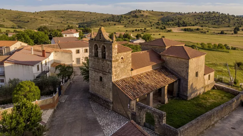 Iglesia de piedra con torre y tejados tradicionales