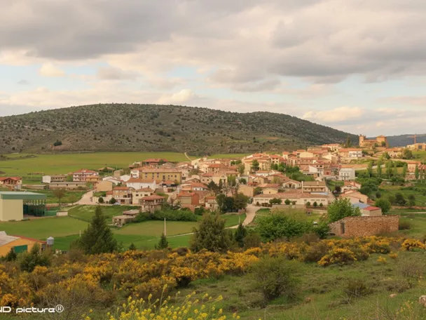 Vista panorámica de un pueblo entre colinas y campos verdes
